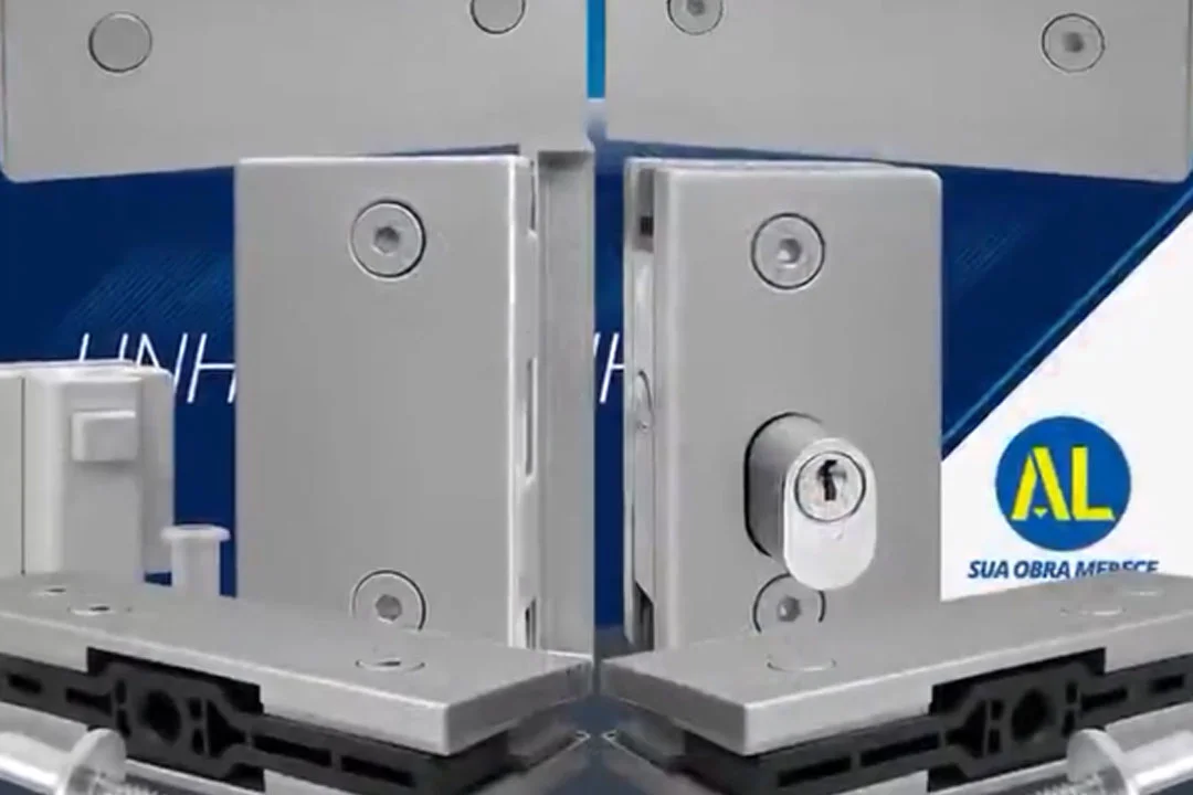 Ferragens em polímero imitando alumínio fosco da Linha Slim AL Indústria, exibindo kit de instalação para vidro temperado com fechadura de cilindro, suportes e roletes sobre fundo azul institucional.