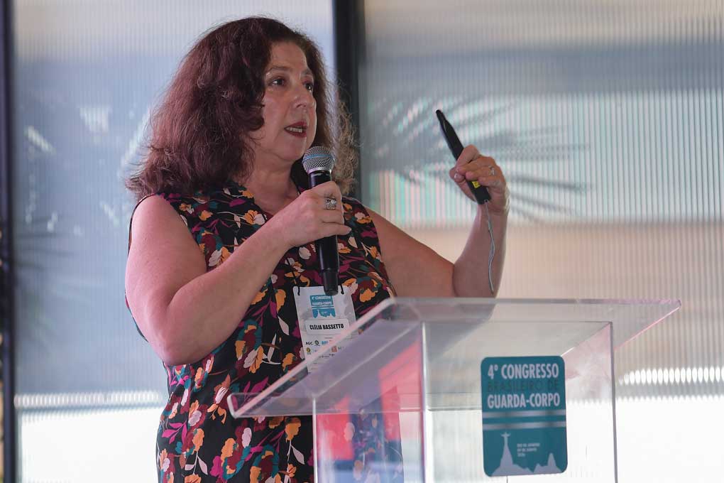 Analista técnica da ABRAVIDRO, Clélia Bassetto, num púlpito abordando as atualizações da ABNT NBR 7199, explicando critérios fundamentais para: Especificação dos vidros de segurança