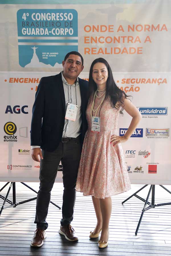 Engenheiro e Engenheira lado a lado com um banner de fundo com os logotipos dos patrocinadores e apoiadores do evento